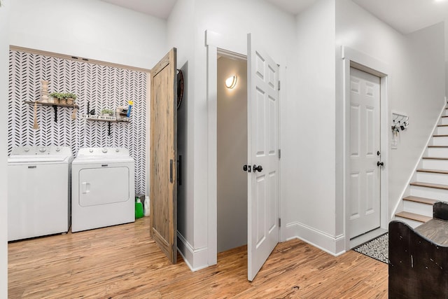 corridor with separate washer and dryer and light hardwood / wood-style floors