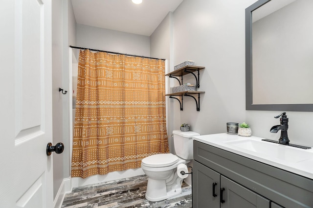 bathroom with hardwood / wood-style flooring, vanity, toilet, and a shower with curtain