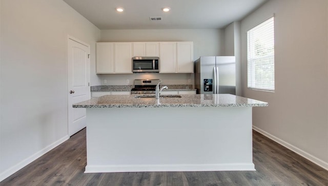 kitchen featuring white cabinetry, sink, stainless steel appliances, and an island with sink