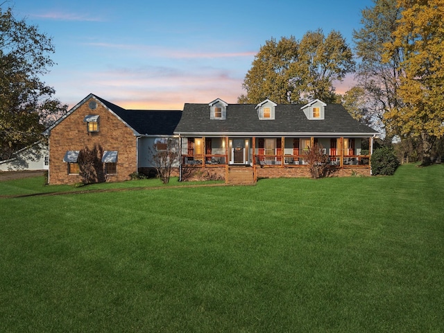 new england style home with a porch and a lawn