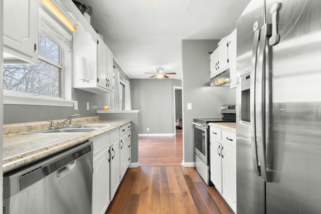 kitchen featuring white cabinetry, ceiling fan, stainless steel appliances, and dark hardwood / wood-style flooring