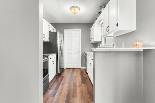 kitchen featuring appliances with stainless steel finishes, a textured ceiling, white cabinets, and dark hardwood / wood-style flooring