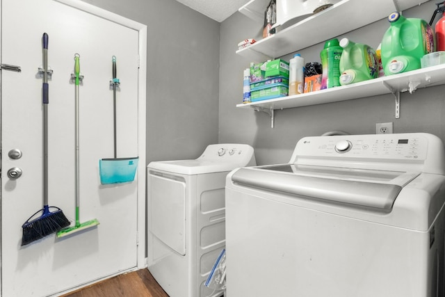 clothes washing area with washer and clothes dryer and dark hardwood / wood-style floors