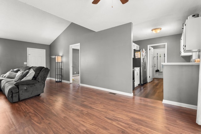 living room featuring ceiling fan, dark hardwood / wood-style flooring, and vaulted ceiling