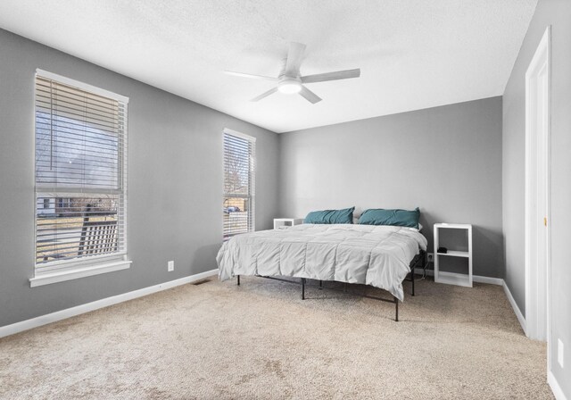 bedroom featuring ceiling fan, carpet floors, and a textured ceiling