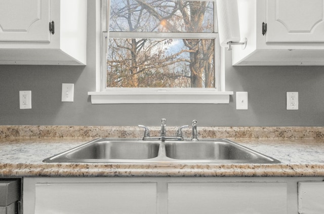 kitchen featuring white cabinetry and sink