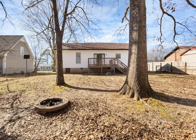 back of house featuring a wooden deck and a fire pit