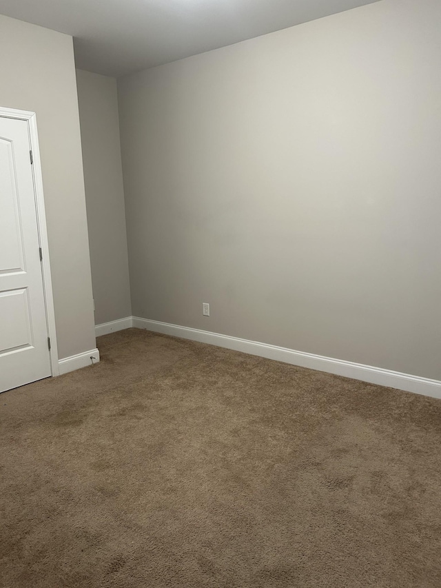 empty room with baseboards and carpet