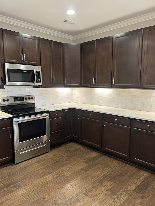 kitchen with decorative backsplash, light countertops, dark wood-style flooring, and stainless steel appliances