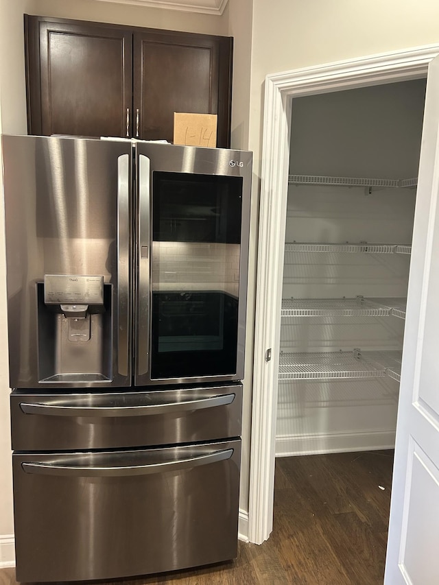 interior details featuring dark wood-style floors, dark brown cabinets, and stainless steel fridge