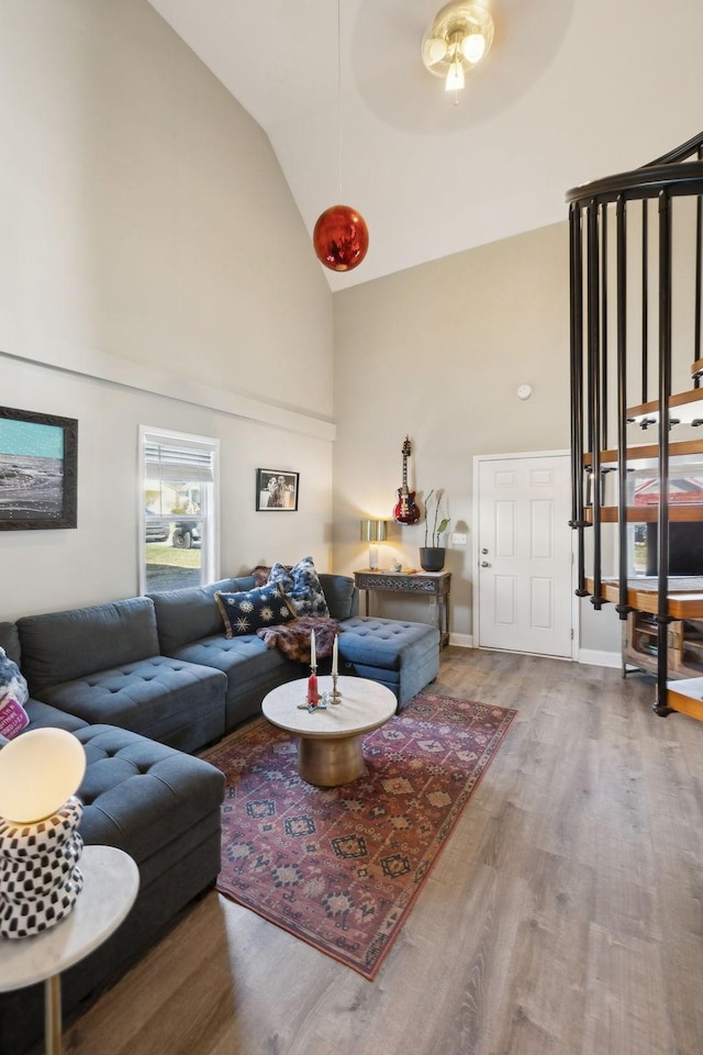 living room with hardwood / wood-style floors, high vaulted ceiling, and ceiling fan