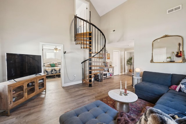 living room with high vaulted ceiling and hardwood / wood-style floors