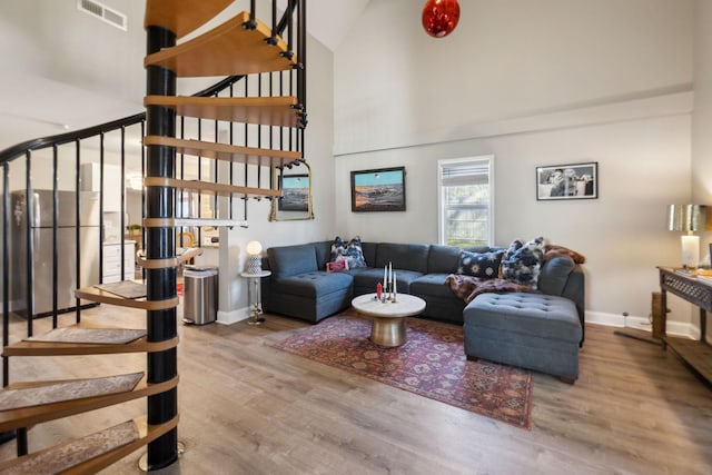 living room featuring high vaulted ceiling and hardwood / wood-style floors