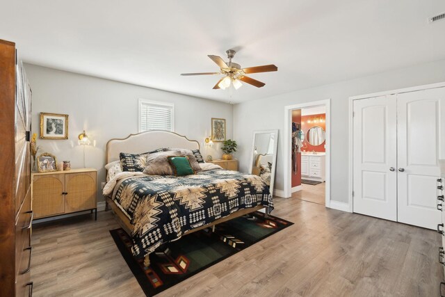 bedroom with ceiling fan, wood-type flooring, ensuite bath, and a closet