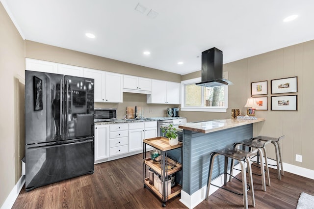 kitchen with appliances with stainless steel finishes, sink, white cabinets, island exhaust hood, and kitchen peninsula