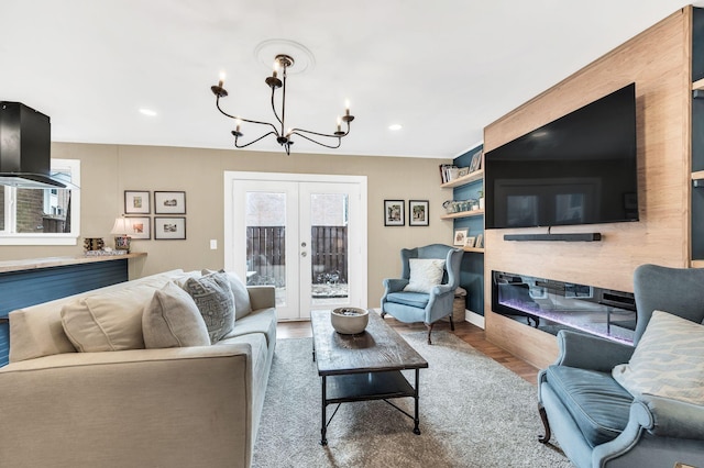 living room with french doors, an inviting chandelier, and light hardwood / wood-style flooring