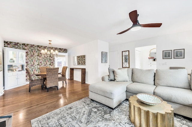 living room with wood-type flooring and ceiling fan with notable chandelier