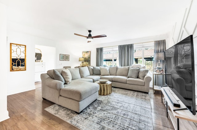 living room featuring ceiling fan and dark hardwood / wood-style flooring