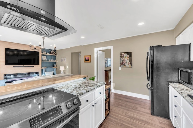 kitchen featuring appliances with stainless steel finishes, light stone counters, light hardwood / wood-style floors, white cabinets, and exhaust hood