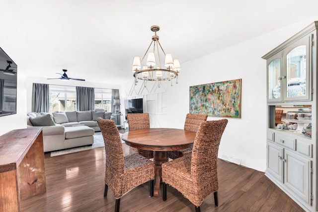 dining space featuring dark hardwood / wood-style floors and ceiling fan with notable chandelier