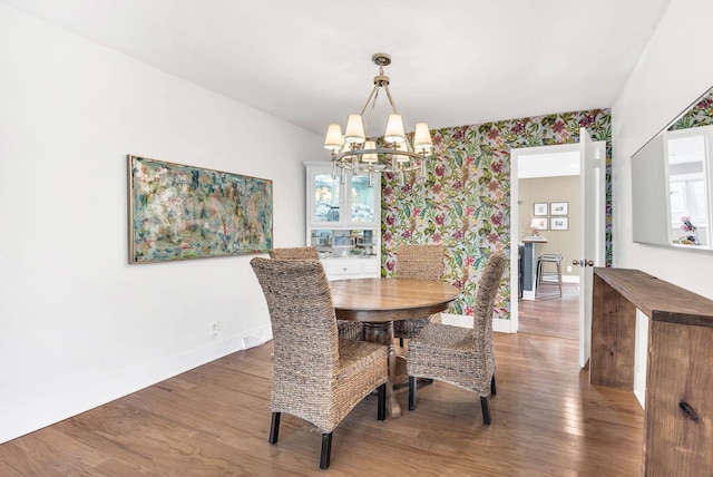 dining area featuring dark wood-type flooring and a chandelier