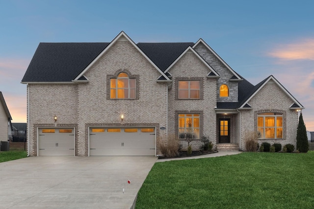 view of front of house featuring a garage, a yard, and central air condition unit