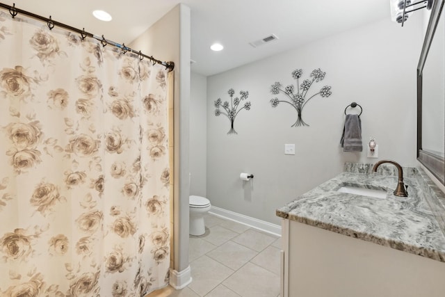 bathroom with tile patterned flooring, vanity, walk in shower, and toilet