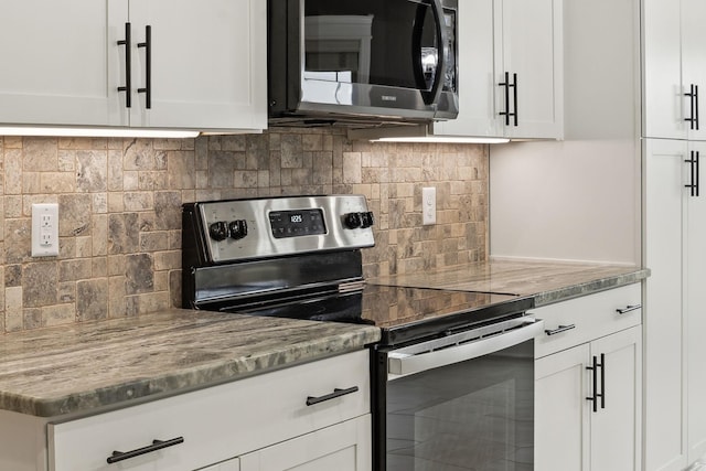 kitchen featuring white cabinetry, backsplash, light stone countertops, and electric range