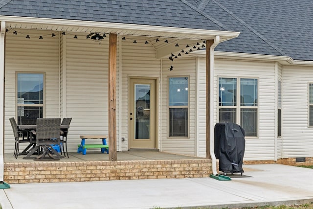 view of exterior entry with a patio area