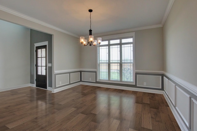 spare room with an inviting chandelier, ornamental molding, and dark hardwood / wood-style flooring