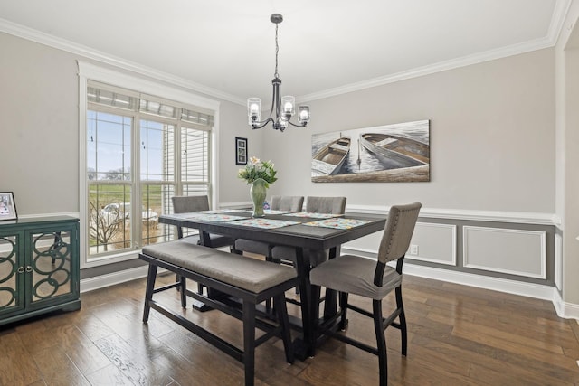 dining area with dark hardwood / wood-style flooring, crown molding, and an inviting chandelier