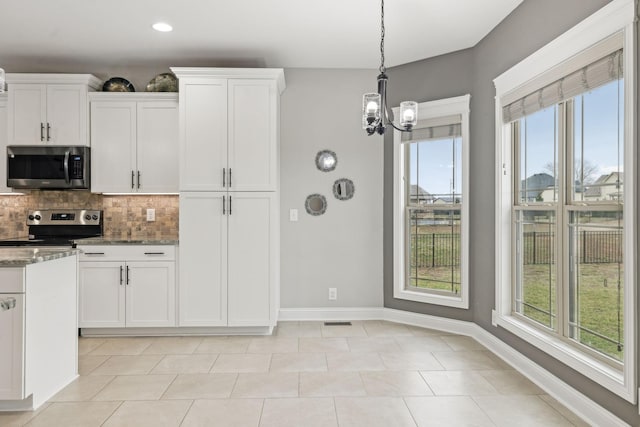 kitchen with white cabinetry, stainless steel appliances, stone countertops, and plenty of natural light