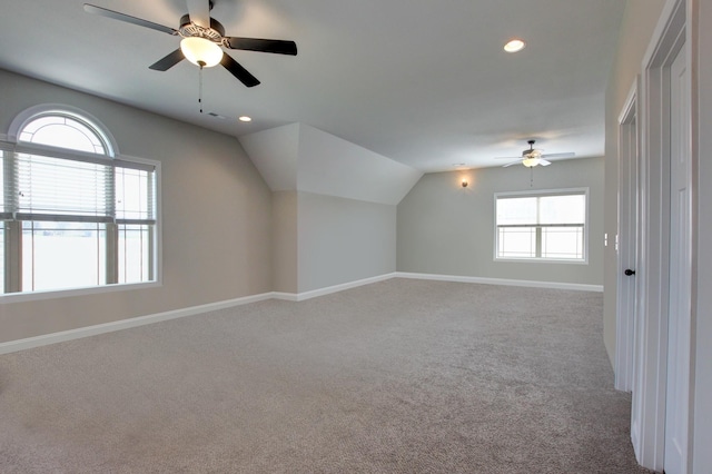 additional living space with ceiling fan, light colored carpet, and vaulted ceiling