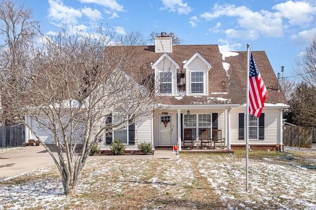 cape cod-style house with roof with shingles, a chimney, a porch, concrete driveway, and fence