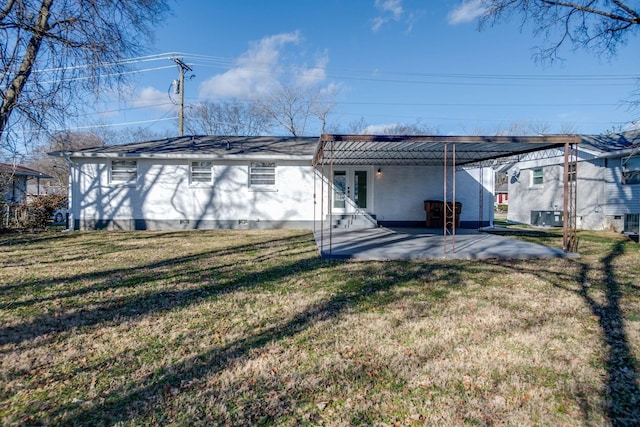 back of house with a lawn and a patio