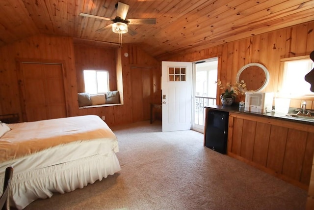 bedroom with multiple windows, vaulted ceiling, wooden walls, and wood ceiling