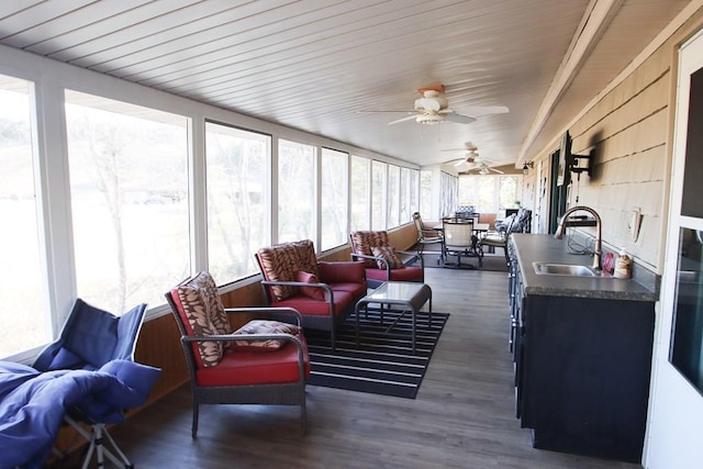 sunroom featuring ceiling fan and sink