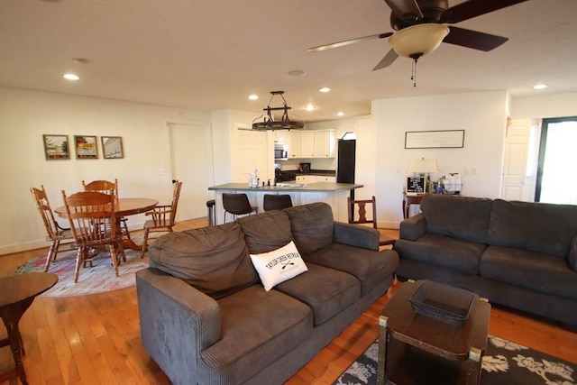 living room with ceiling fan and light wood-type flooring