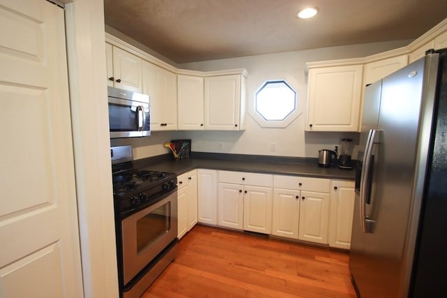 kitchen with white cabinetry, light hardwood / wood-style flooring, and appliances with stainless steel finishes