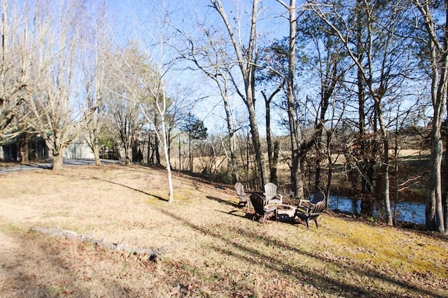 view of yard with a water view and a fire pit