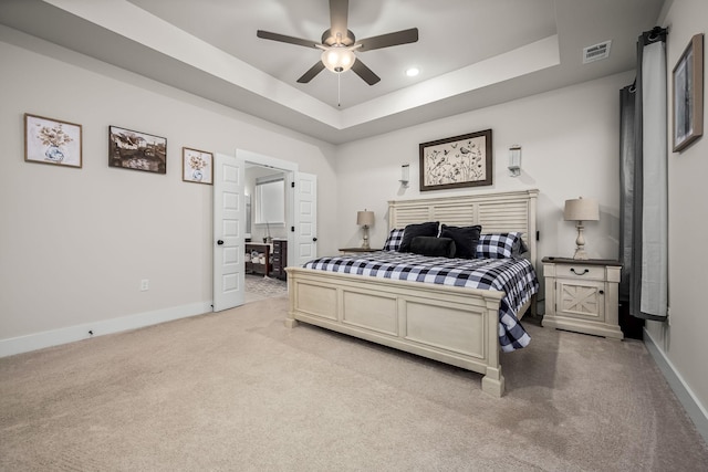 carpeted bedroom with ceiling fan and a tray ceiling