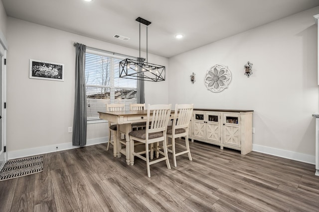 dining space featuring dark hardwood / wood-style floors and a chandelier