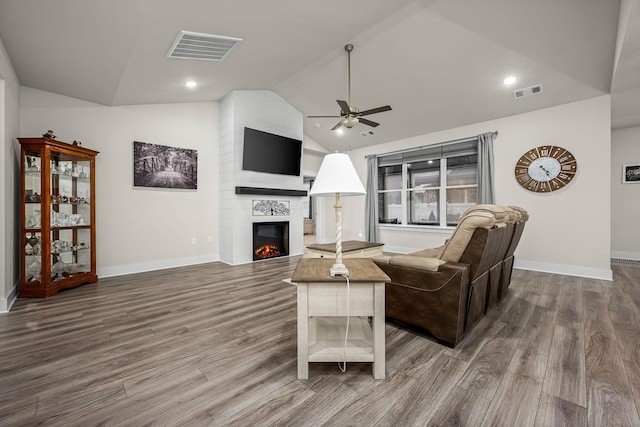 living room featuring ceiling fan, lofted ceiling, a fireplace, and hardwood / wood-style floors