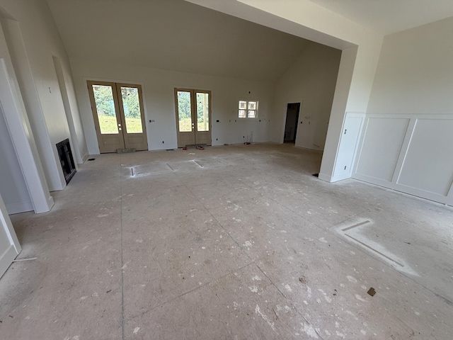 3944 Chapel Hill Rd, Clarksville, TN 37040 - unfurnished living room featuring french doors, plenty of natural light, vaulted ceiling, a decorative wall, and a wainscoted wall