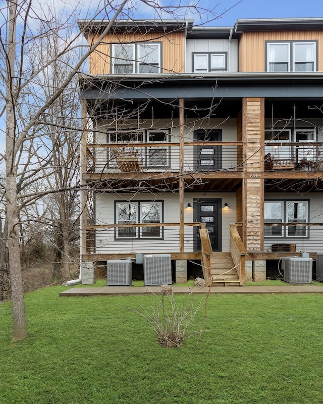 back of property with a yard and central AC unit