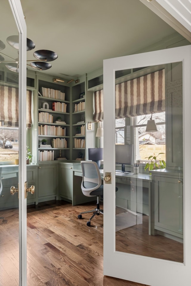 office with built in desk and light hardwood / wood-style flooring