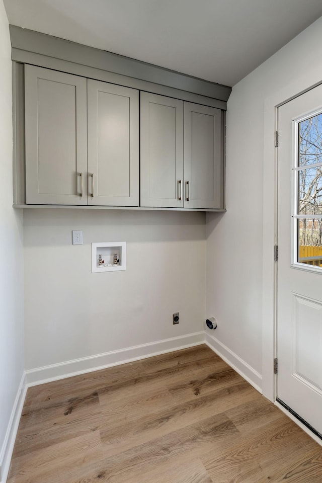 clothes washing area with cabinets, washer hookup, electric dryer hookup, and light wood-type flooring