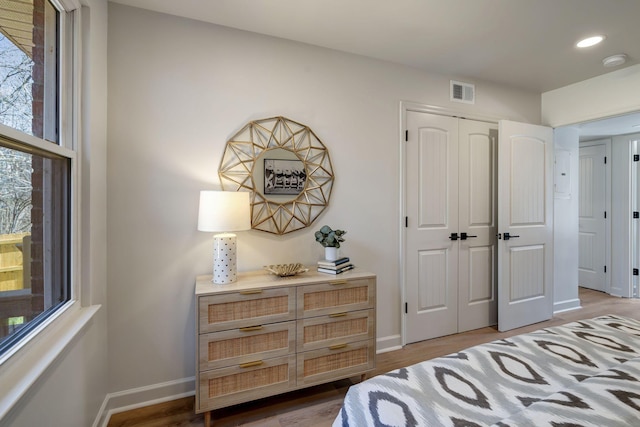 bedroom with wood-type flooring and a closet