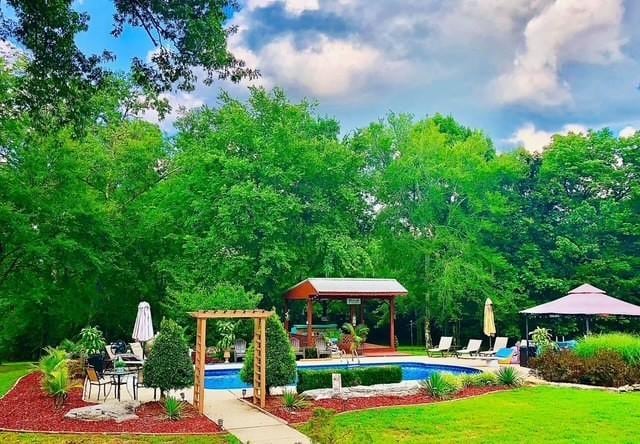 view of playground featuring a yard, a gazebo, and a patio area