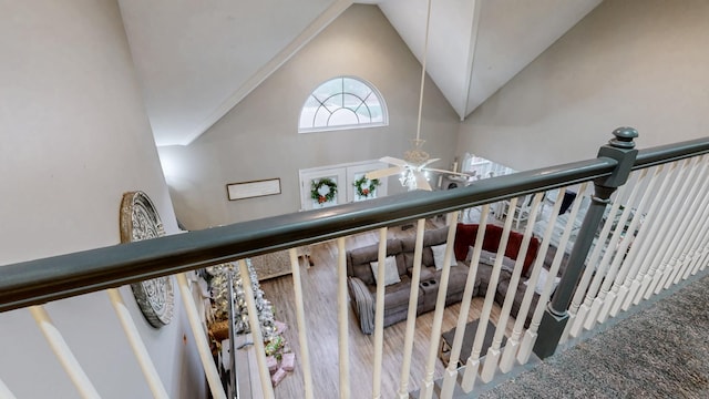 stairway with wood-type flooring and high vaulted ceiling